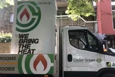 Side of white van, from Cedar Green saying "we bring the heat"